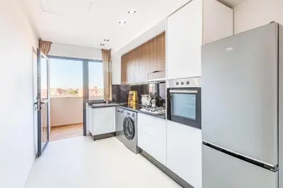 a kitchen with white cabinets and stainless steel appliances at Appart 3 CH Menara Garden in Marrakech