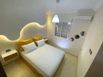 a bedroom with a bed with yellow pillows and a window at Appartement à Marrakech confortable et équipe in Marrakech