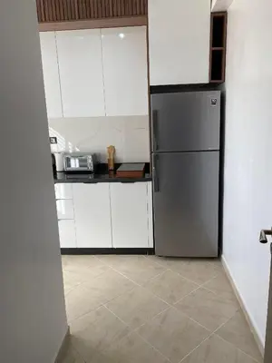 a kitchen with a refrigerator and white cabinets at Appartement à Marrakech confortable et équipe in Marrakech