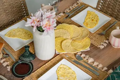 a table with plates of food and a vase of flowers at Riad Zahra Private Pool and Breakfast10min Jemaa in Marrakech