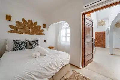a bedroom with a large white bed and a doorway at Riad Zahra Private Pool and Breakfast10min Jemaa in Marrakech