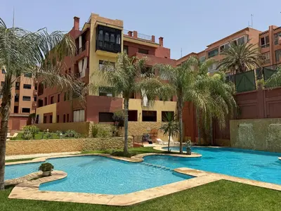 a swimming pool in front of a building at Bel Appartement 2 Chambres spacieux avec Piscine in Marrakech