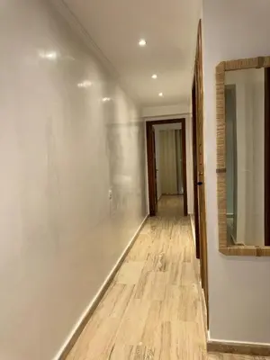 a hallway with white walls and a mirror at Bel Appartement 2 Chambres spacieux avec Piscine in Marrakech