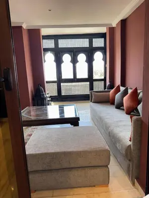 a living room with a couch and a table at Bel Appartement 2 Chambres spacieux avec Piscine in Marrakech