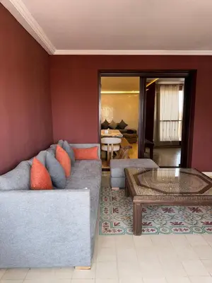 a living room with a couch and a table at Bel Appartement 2 Chambres spacieux avec Piscine in Marrakech