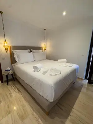a large white bed with two towels on it at Bel Appartement 2 Chambres spacieux avec Piscine in Marrakech