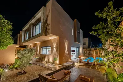 a villa with a swimming pool at night at Luxury Villa Olivier, Stylish & Breakfast included in Marrakech
