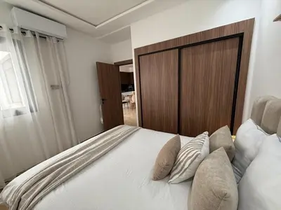 a bedroom with a large bed with a wooden headboard at Beautiful modern apartment 1 bedroom 2 people Menara Garden 2 in Marrakech
