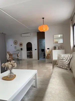 a living room with a couch and a table at Beautiful modern apartment 1 bedroom 2 people Menara Garden 2 in Marrakech