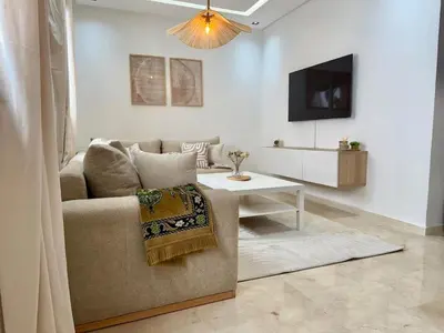 a living room with a couch and a tv at Beautiful modern apartment 1 bedroom 2 people Menara Garden 2 in Marrakech