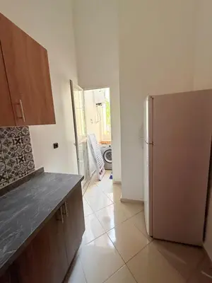 a kitchen with a refrigerator and a door to a yard at 2 Aprt Moderne Neuf Adapté Au Famille in Marrakech