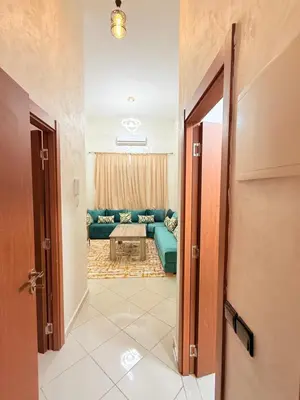 a hallway leading to a living room with a blue couch at 2 Aprt Moderne Neuf Adapté Au Famille in Marrakech