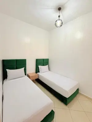 two beds sitting next to each other in a room at 2 Aprt Moderne Neuf Adapté Au Famille in Marrakech