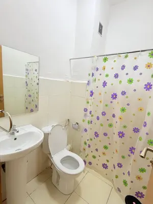 a bathroom with a toilet and a sink and a shower curtain at 2 Aprt Moderne Neuf Adapté Au Famille in Marrakech