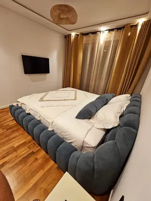 a bedroom with a large bed with a large ottoman at Luxurious New Designer Apartment in Marrakech in Marrakech