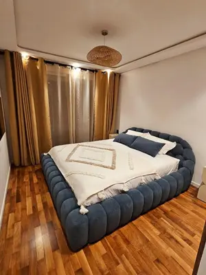 a bedroom with a large bed with a large bed frame at Luxurious New Designer Apartment in Marrakech in Marrakech