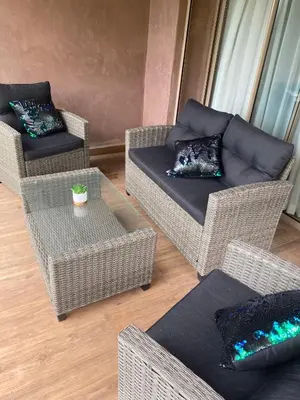 a living room with wicker chairs and couches at appartement à prestigia golf marrakech- SAPHIR in Marrakech