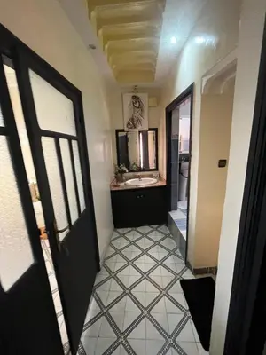 a hallway with a bathroom with a sink and a door at Riad Darkom Private in Marrakech