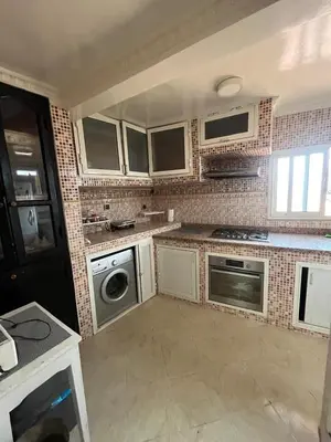 a kitchen with white appliances and a brick wall at Riad Darkom Private in Marrakech