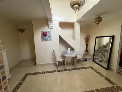 a dining room with a table and chairs and a mirror at Riad Darkom Private in Marrakech