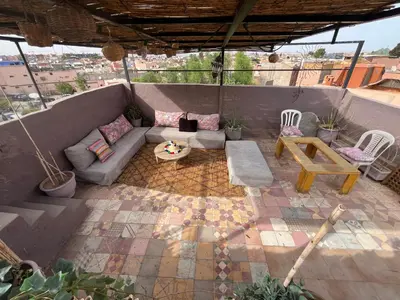 a patio with a couch and a table and chairs at Riad Darkom Private in Marrakech