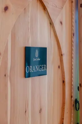 a sign that reads orange on a wooden wall at Riad fabi in Marrakech