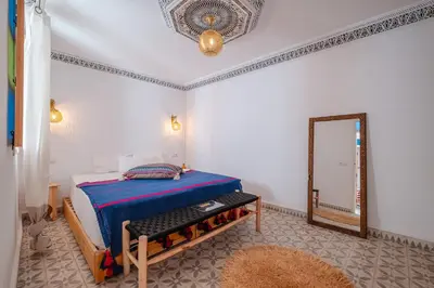 a bedroom with a bed and a mirror at Riad fabi in Marrakech
