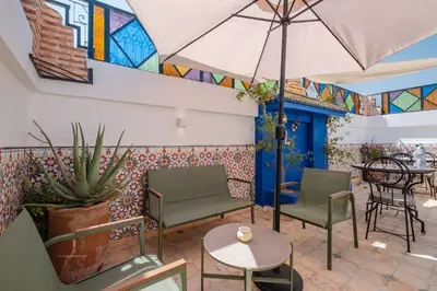 a patio with chairs and an umbrella and a table at Riad fabi in Marrakech