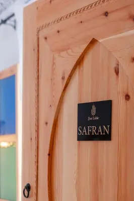 a sign on the door of a wooden building at Riad fabi in Marrakech