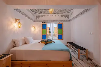 a bedroom with a large white bed and a window at Riad fabi in Marrakech