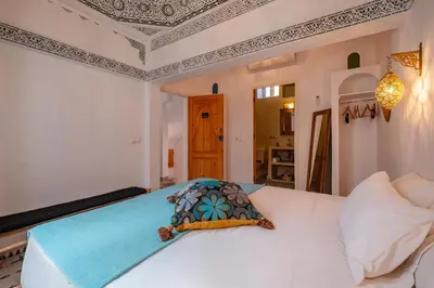 a bedroom with a white bed with a pillow on it at Riad fabi in Marrakech