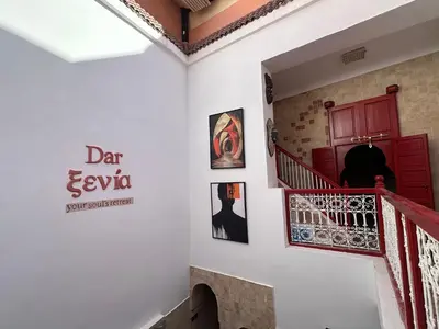a staircase with a red door and posters on the wall at Your Soul's Retreat-Entire Riad in Marrakech