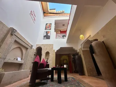 a hallway with a table and chairs in a building at Your Soul's Retreat-Entire Riad in Marrakech