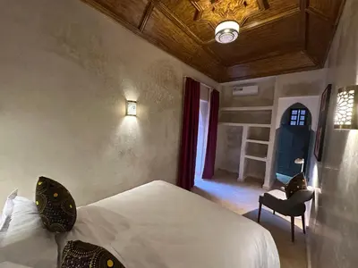 a bedroom with a bed and a chair and a window at Your Soul's Retreat-Entire Riad in Marrakech
