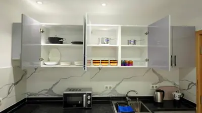 a kitchen with white cabinets and a microwave at Charming Marrakech Appartement in Marrakech
