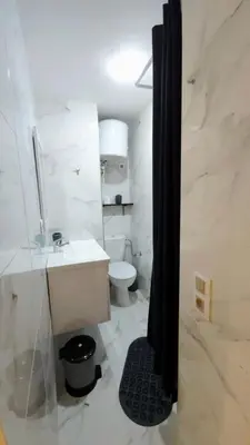 a white bathroom with a sink and a toilet at Charming Marrakech Appartement in Marrakech