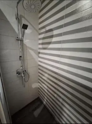 a bathroom with a shower with a shadow on the wall at Modern Marrakech Apartment in Marrakech