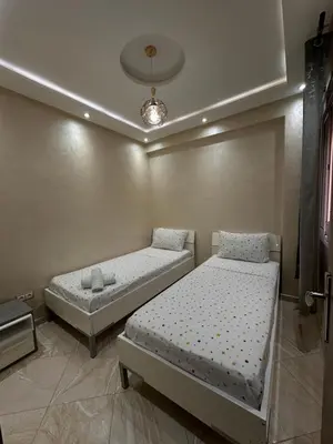 a bedroom with two beds and a ceiling at Modern Marrakech Apartment in Marrakech