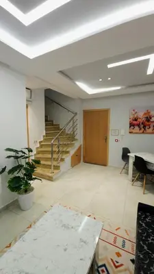 a large room with a staircase and a table at Charming Marrakech Duplex in Marrakech