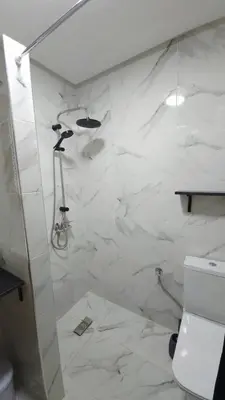 a white bathroom with a shower and a toilet at Charming Marrakech Duplex in Marrakech