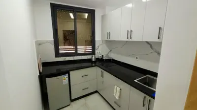 a kitchen with white cabinets and a window at Charming Marrakech Duplex in Marrakech