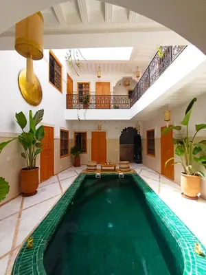 an indoor swimming pool in a building with a swimming pool at Riad DabaKech in Marrakech