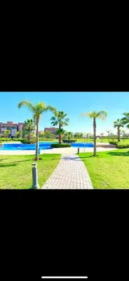 a brick walkway with palm trees in a park at Marrakech Prestigia golf city in Marrakech