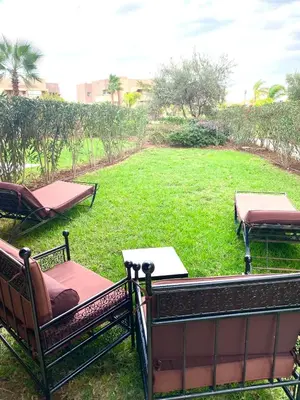 a balcony with chairs and a yard with a park at Marrakech Prestigia golf city in Marrakech