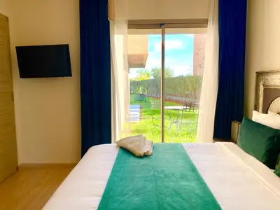 a bedroom with a bed with a large window at Marrakech Prestigia golf city in Marrakech