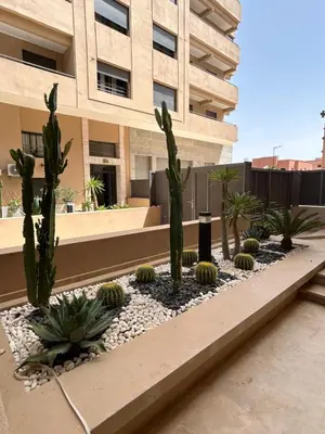 a courtyard with cacti and plants in front of a building at Appartement à Marrakech 2 chambres avec piscine et parking Palmeraie Gates in Marrakech