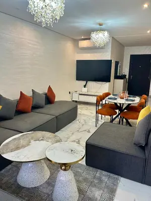 a living room with a couch and a table at Appartement à Marrakech 2 chambres avec piscine et parking Palmeraie Gates in Marrakech
