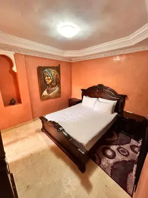 a bedroom with a bed and a painting on the wall at L'escapade Marrakech - Appartement familiale vue sur Piscine in Marrakech