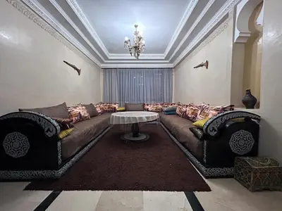 a living room with a couch and a table at L'escapade Marrakech - Appartement familiale vue sur Piscine in Marrakech
