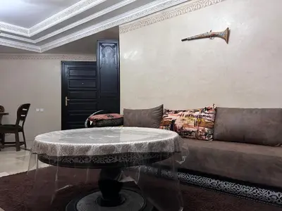 a living room with a couch and a table at L'escapade Marrakech - Appartement familiale vue sur Piscine in Marrakech